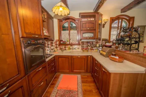 Traditional kitchen with wooden cabinets and a built-in oven. - image 39