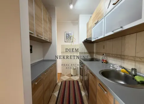 Manja uska kuhinja sa drvenim elementima i sudoperom. - image 11