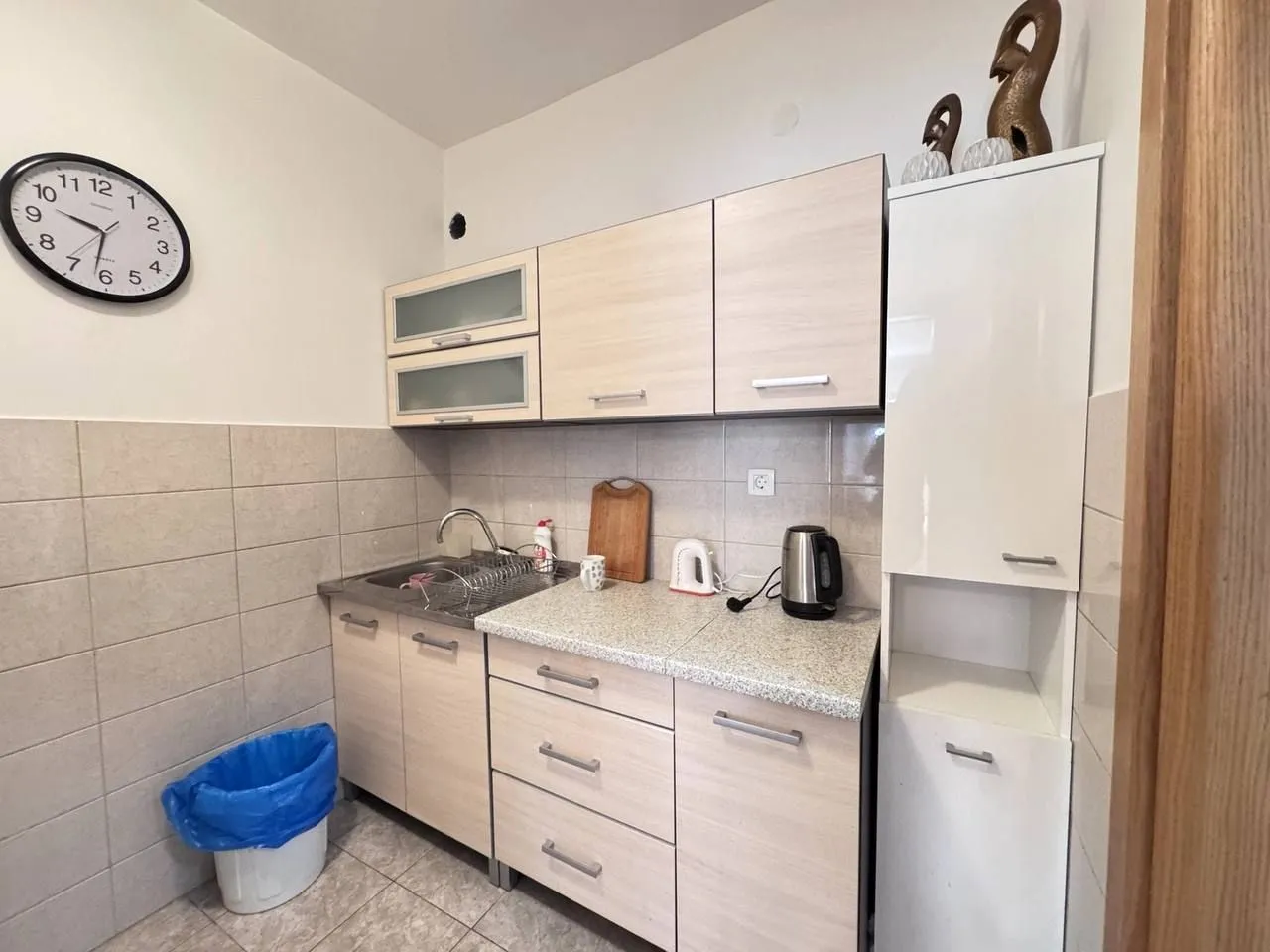 Smaller kitchen with light-colored cabinets and a sink.