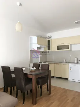 Kitchen with dining area equipped with light-colored cabinets and a dark dining table. - image 10