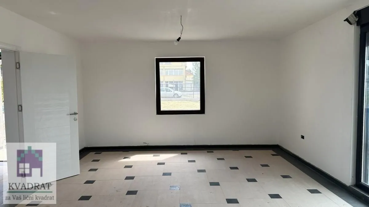 Empty room with white walls, tiled floor and a single window.