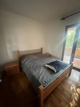 Simple bedroom with a wooden double bed and access to a terrace. - image 6