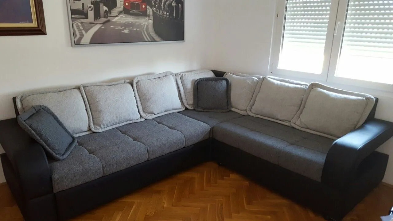 Living room with a corner sofa and parquet flooring.