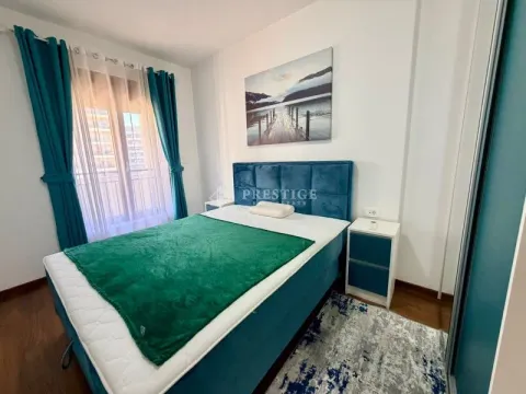 Furnished bedroom with a double bed and blue curtains. - image 8