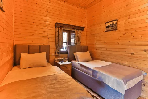 Spavaća soba sa dva singl kreveta obložena drvenim panelima. - image 12