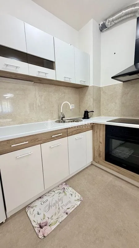 Modern kitchen with white cabinets and a built-in oven.