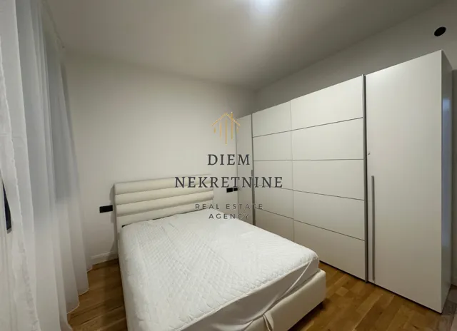 Bright bedroom with a double bed and a large fitted wardrobe.