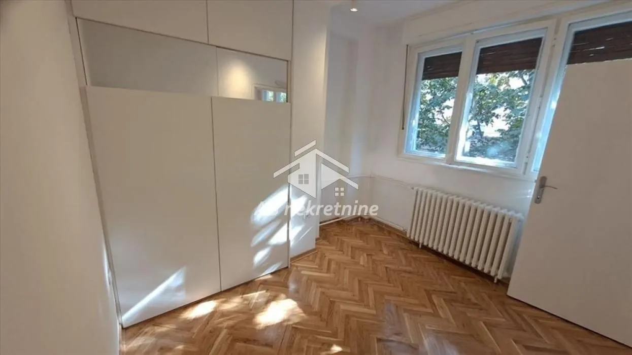 Smaller bedroom with a built-in wardrobe and parquet flooring.