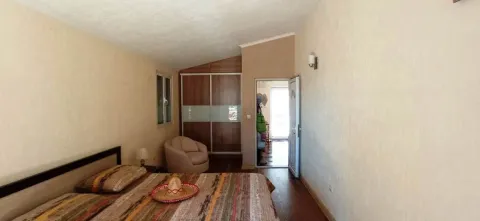 Furnished bedroom with a double bed, wardrobe, and an armchair. - image 7