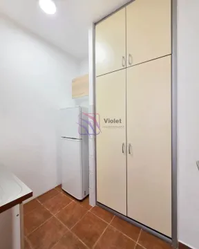 Small kitchen with a white refrigerator and fitted cabinets. - image 5