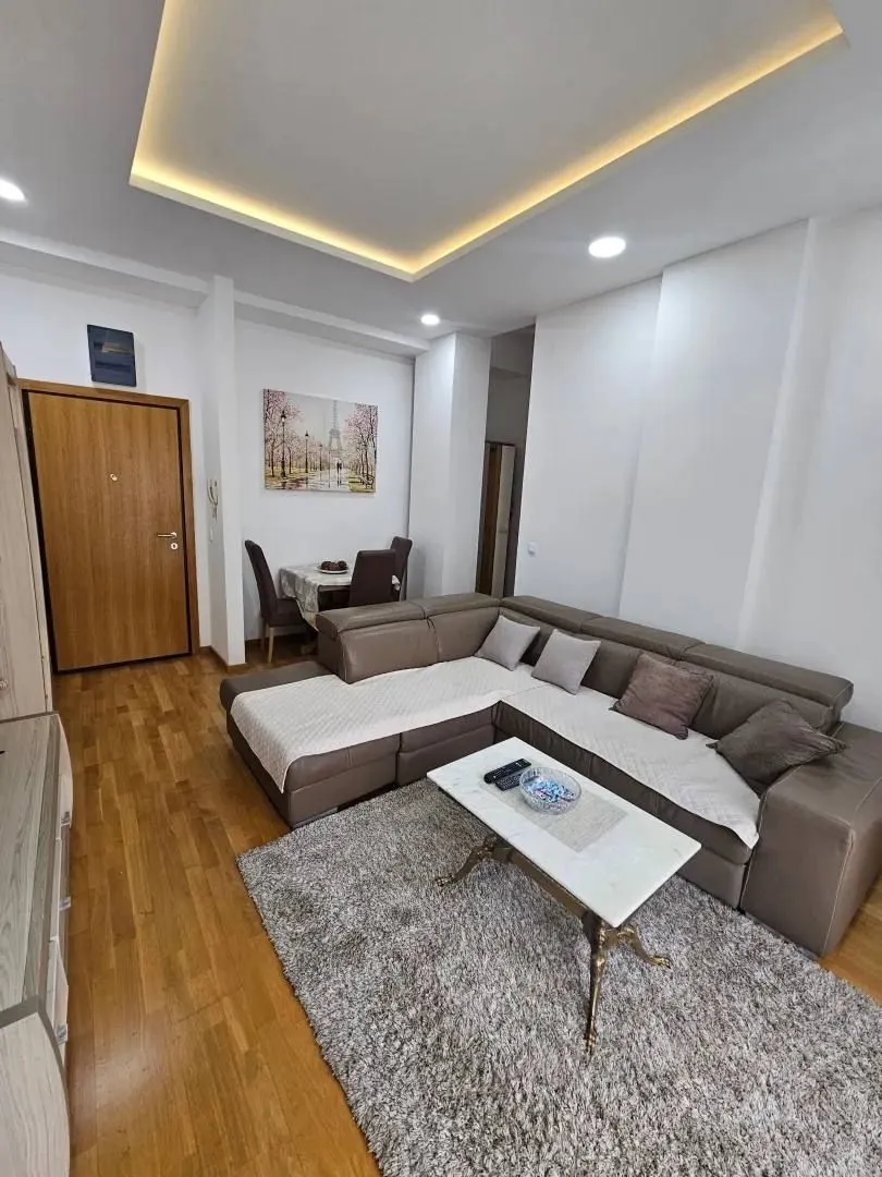 Comfortable living room with a sectional sofa, rug, and dining area in the background.