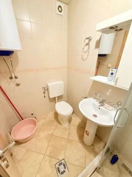 Small bathroom with tiles, washbasin, toilet, and shower cabin. - image 9