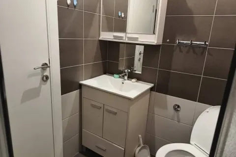 Small bathroom with a sink, cabinet, mirror, and toilet. - image 6