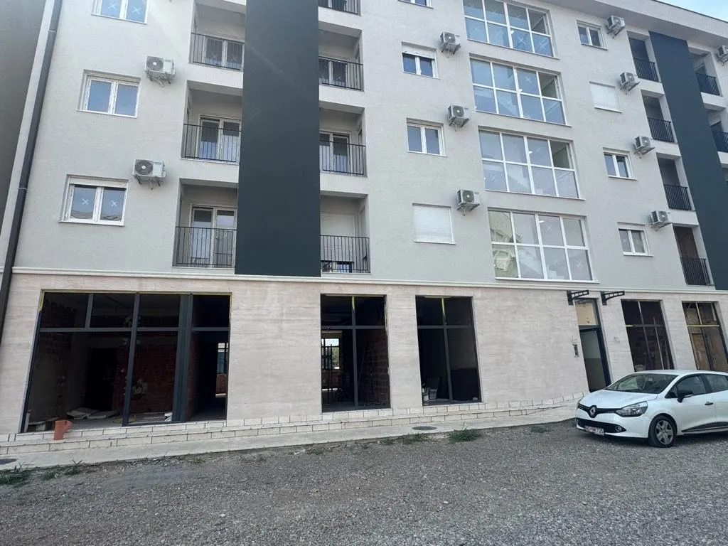 Exterior view of a multi-family residential building with commercial space on the ground floor.