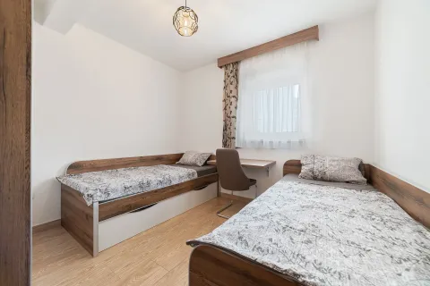 Bedroom with two single beds and a desk under the window. - image 5