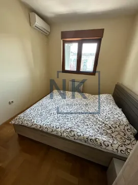 Manja spavaća soba sa bračnim krevetom, prozorom i klima uređajem. - image 9