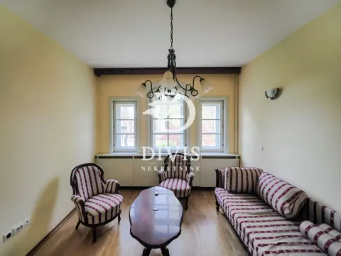Living room with seating furniture and three windows. - image 10