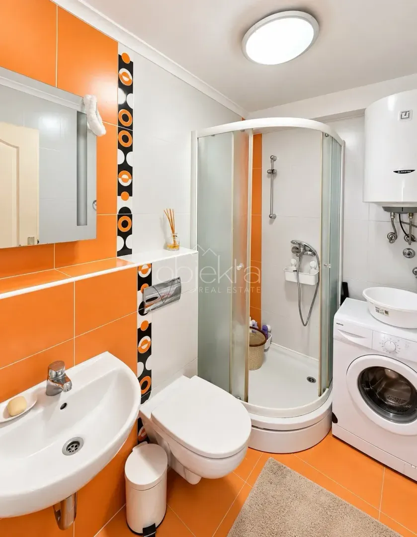 Kupatilo sa tuš kabinom, umivaonikom, WC šoljom i veš mašinom.