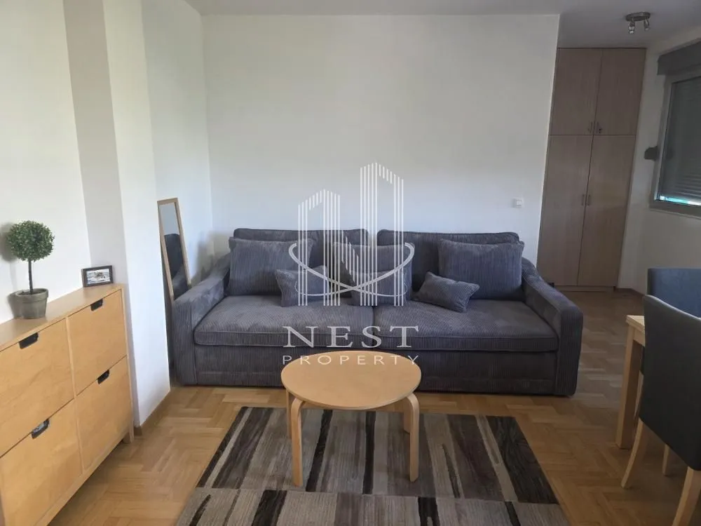 Living room with a grey sofa, coffee table, and wooden furniture.