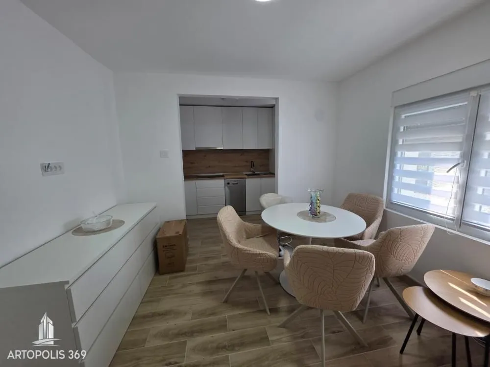 Dining area with a table and chairs and a view of the kitchen.