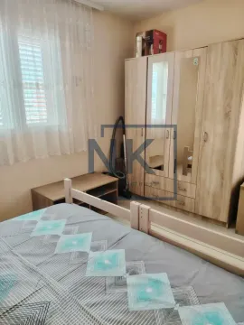 Bedroom with a bed, a large wooden wardrobe, and a window with curtains. - image 5