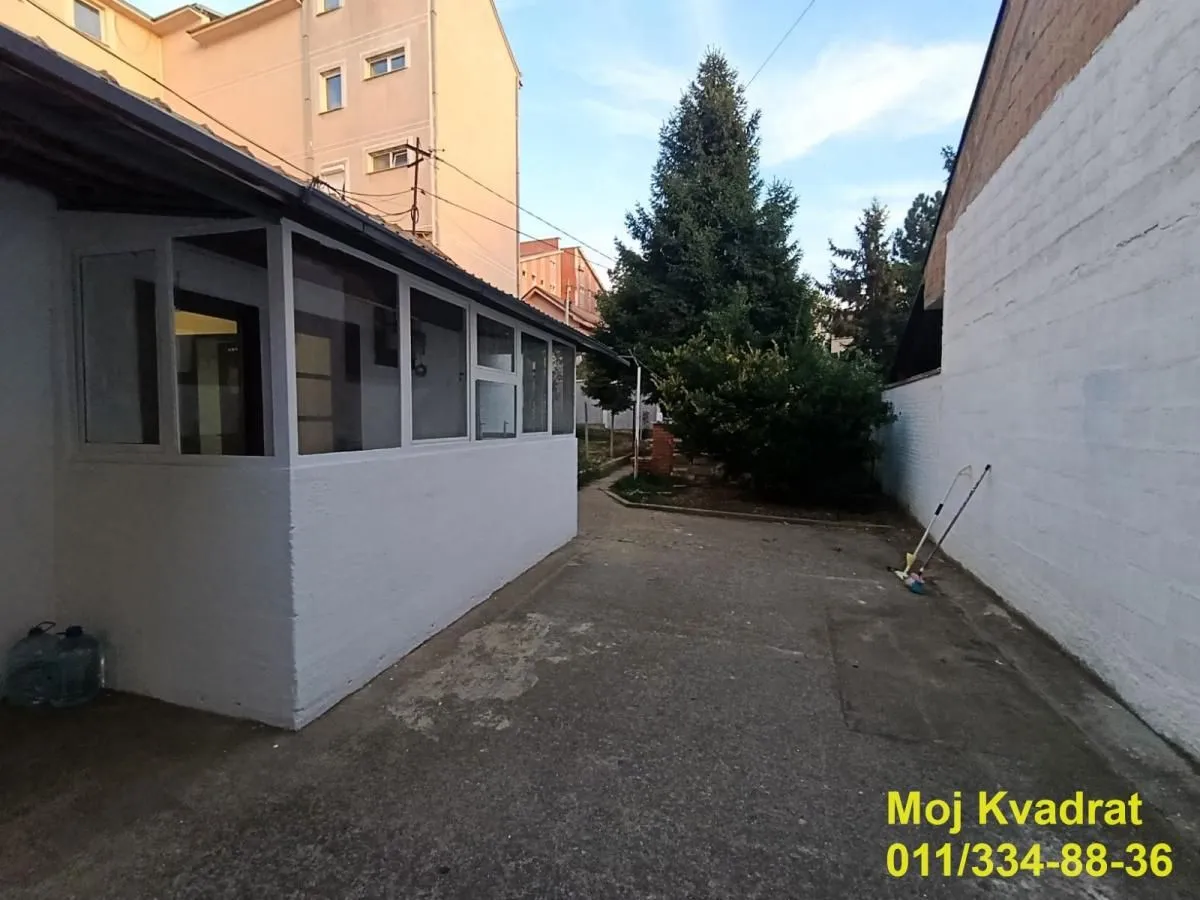 Yard with driveway and part of the house featuring a glazed veranda.