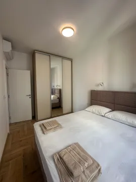 Svijetla spavaća soba sa bračnim krevetom, ormarom i drvenim podom. - image 17
