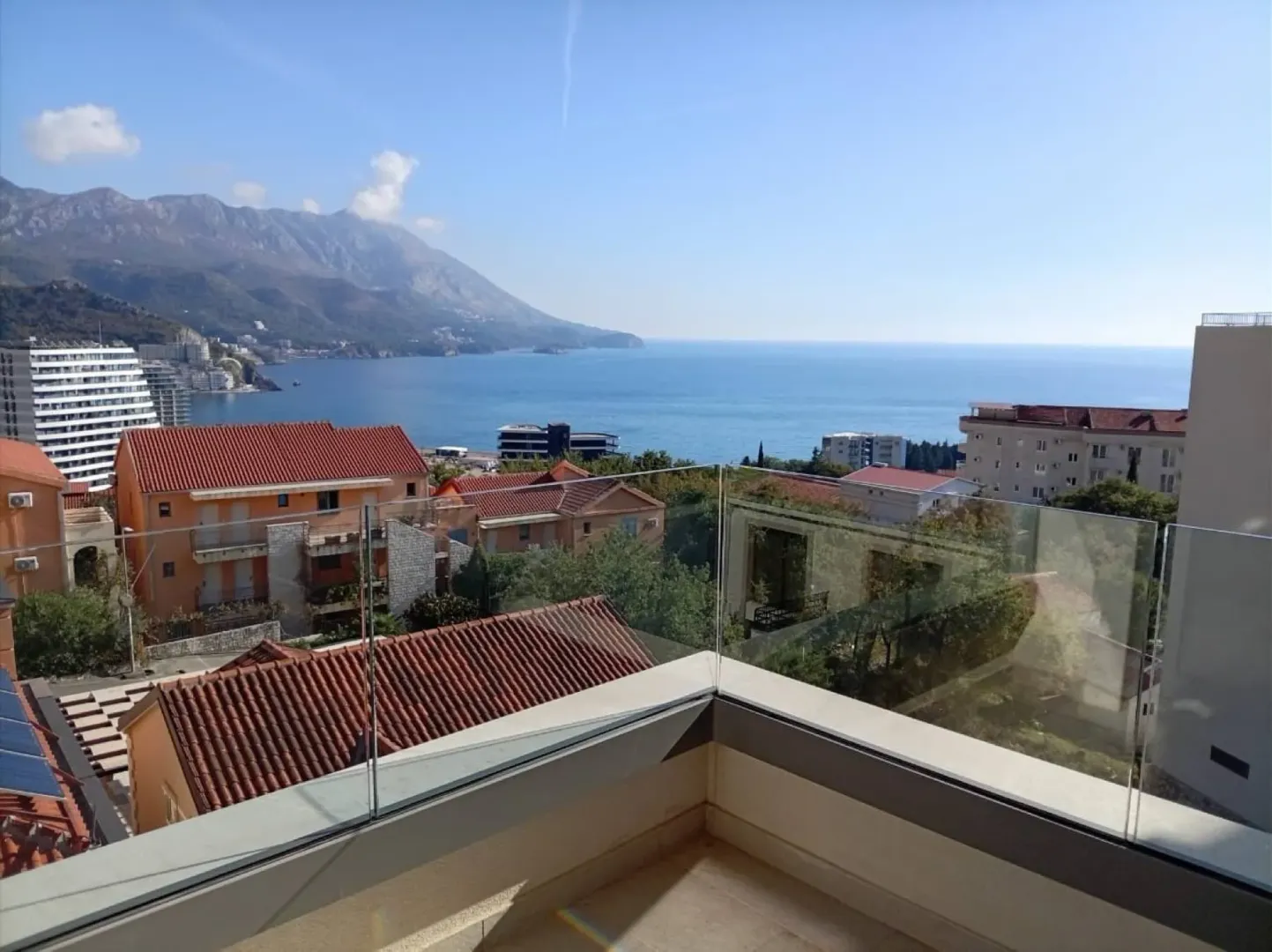 Terasa sa staklenom ogradom i pogledom na more i planine.