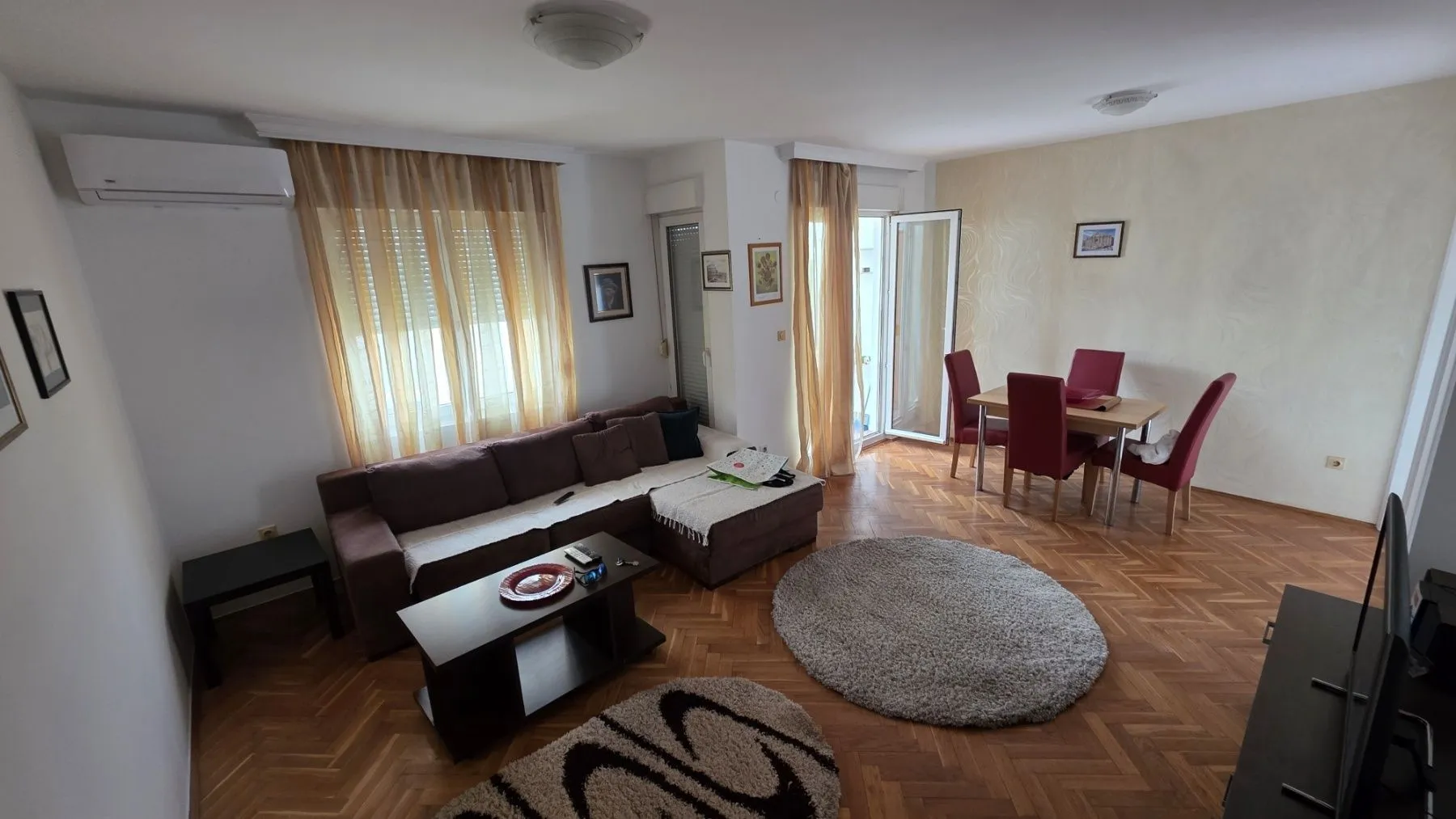 Bright living room with a seating area and a dining table.