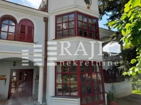 Exterior view of the house with a white facade and brown window frames. - image 3