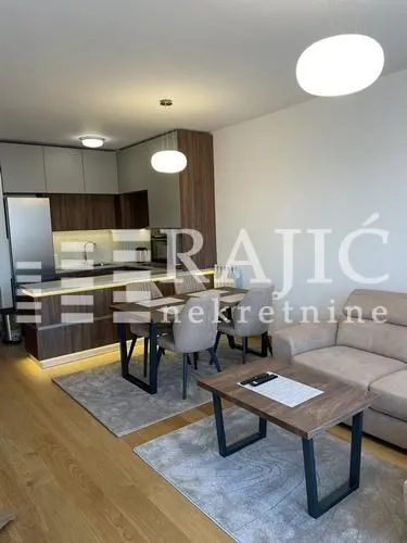 Modern living room with dining area and kitchen in the background.