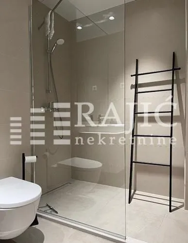 Modern bathroom with a walk-in shower and black decorative elements.