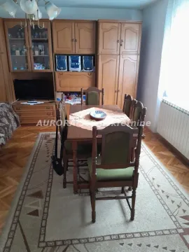 Trpezarija sa drvenim stolom i stolicama, vitrinom i parketom na podu. - image 4