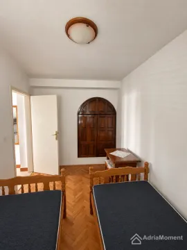 Spavaća soba sa dva drvena kreveta i ugradnim ormarom. - image 8