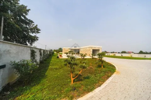 View of the courtyard and driveway with landscaped green areas and a fence. - image 9