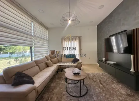 Modern and bright living room with a corner sofa, TV unit, and large windows. - image 2