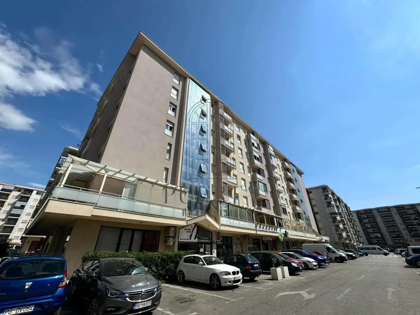 Exterior view of an apartment building with parking in front.