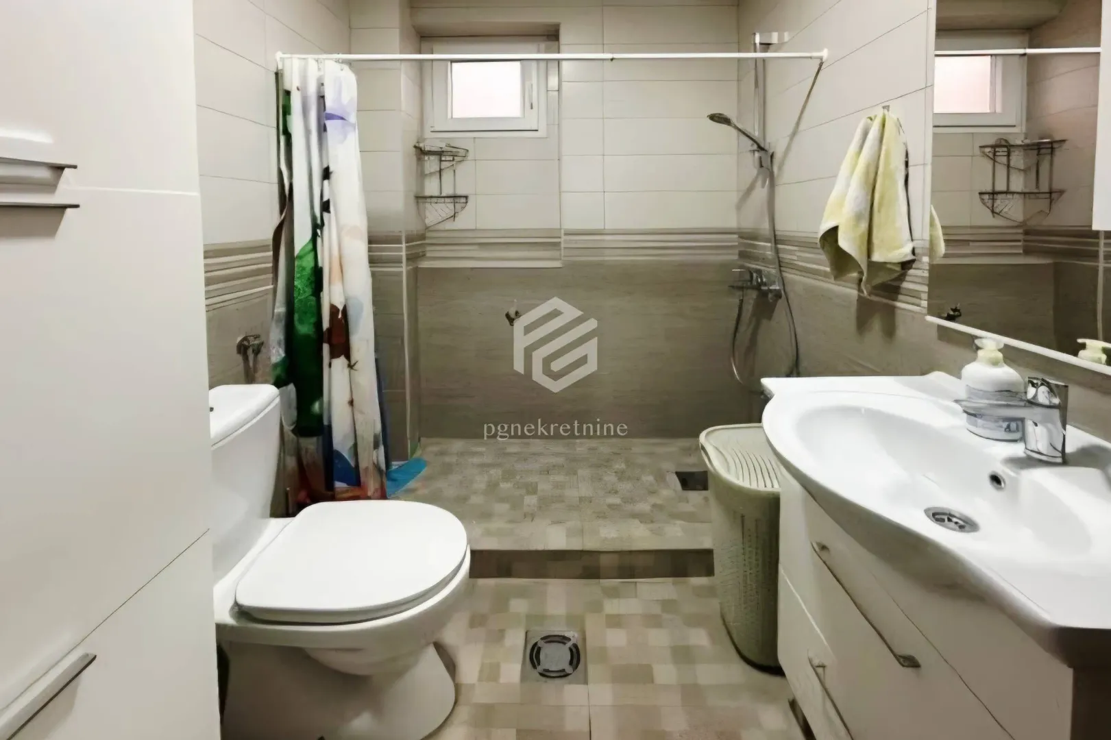 Bathroom equipped with a washbasin, toilet, and a shower area with a curtain.