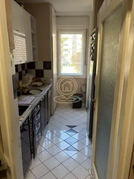 Small narrow kitchen with white cabinets and a window at the end. - image 7