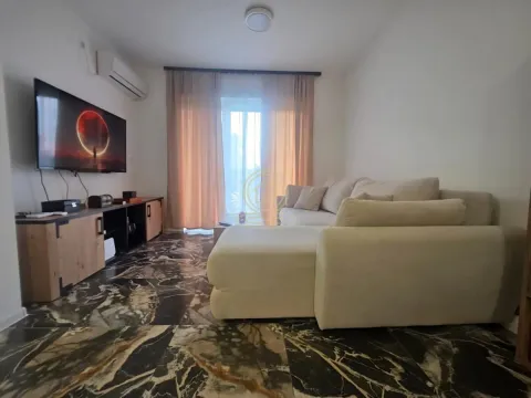 Dnevna soba sa ugaonom garniturom, televizorom i izlazom na terasu. - image 3