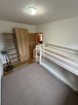 Bedroom with a bunk bed, wooden wardrobe and shelving unit. - image 9