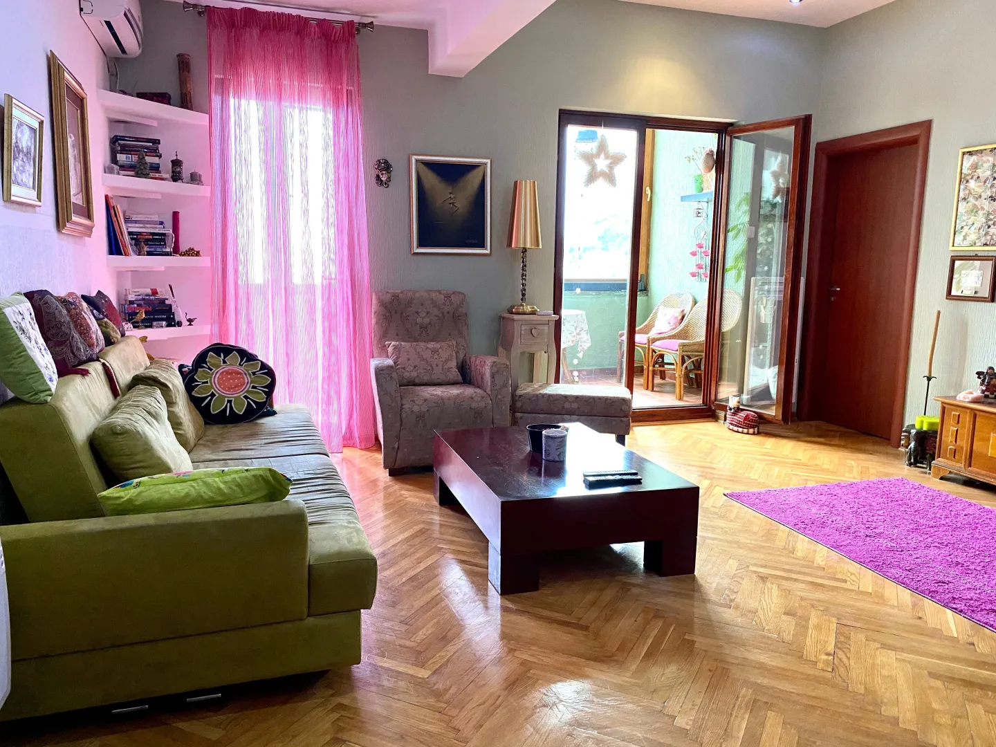 Dnevna soba sa garniturom, stočićem i izlazom na terasu.