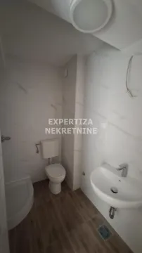 Small bathroom with a shower, washbasin, and toilet. - image 5