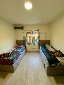 Bedroom with two single beds and air conditioning. - image 8