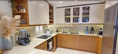 Opremljena kuhinja sa drvenim elementima i belim gornjim ormarićima. - image 6