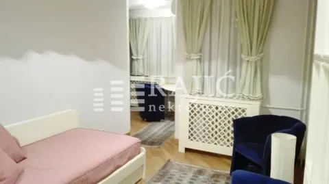 Dnevna soba sa krevetom i plavom foteljom. - image 14