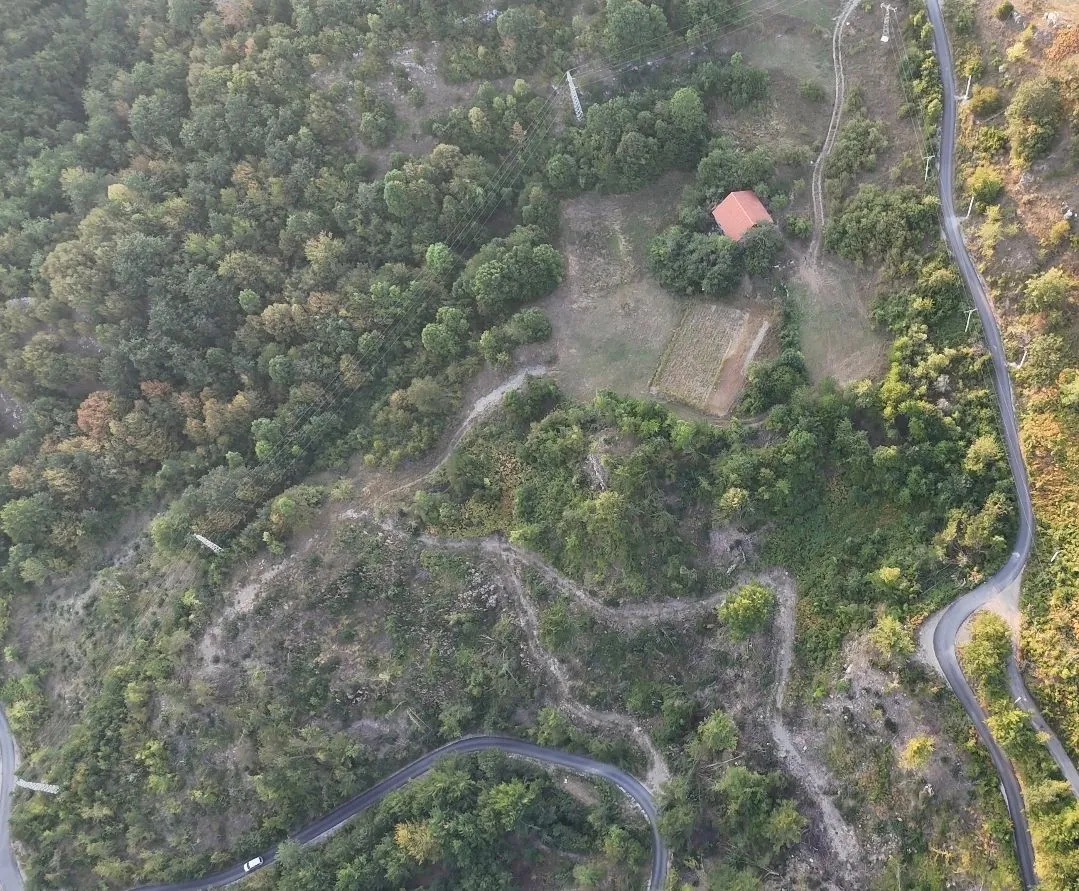 Pogled iz vazduha na plac sa kućom i okruženjem u prirodi.