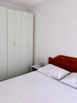 Furnished bedroom with a double bed, wardrobe, and a bedside table with a lamp. - image 2
