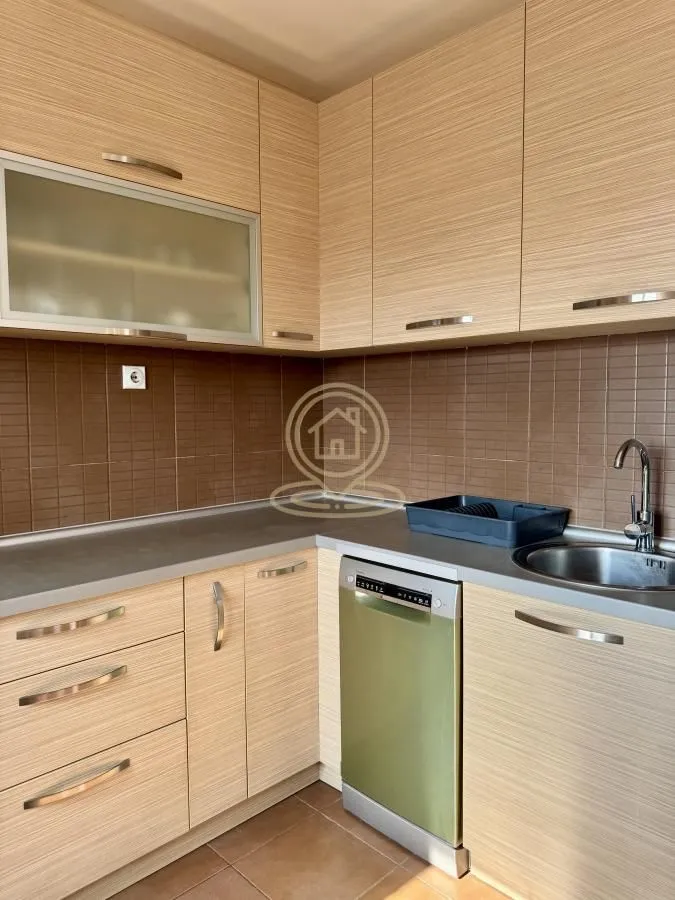 Corner kitchen with wooden cabinetry, a sink, and a built-in dishwasher.