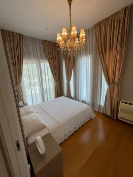 Bedroom with a double bed, wooden flooring, and large windows with curtains. - image 8